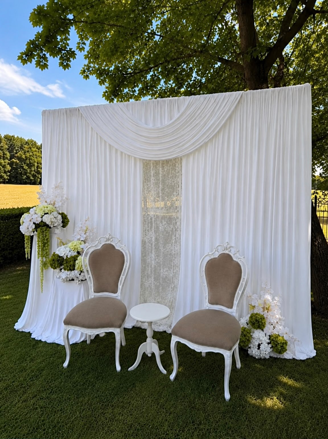Witte gordijnbackdrop buiten met kanten middenbaan, twee stoelen en bloemen