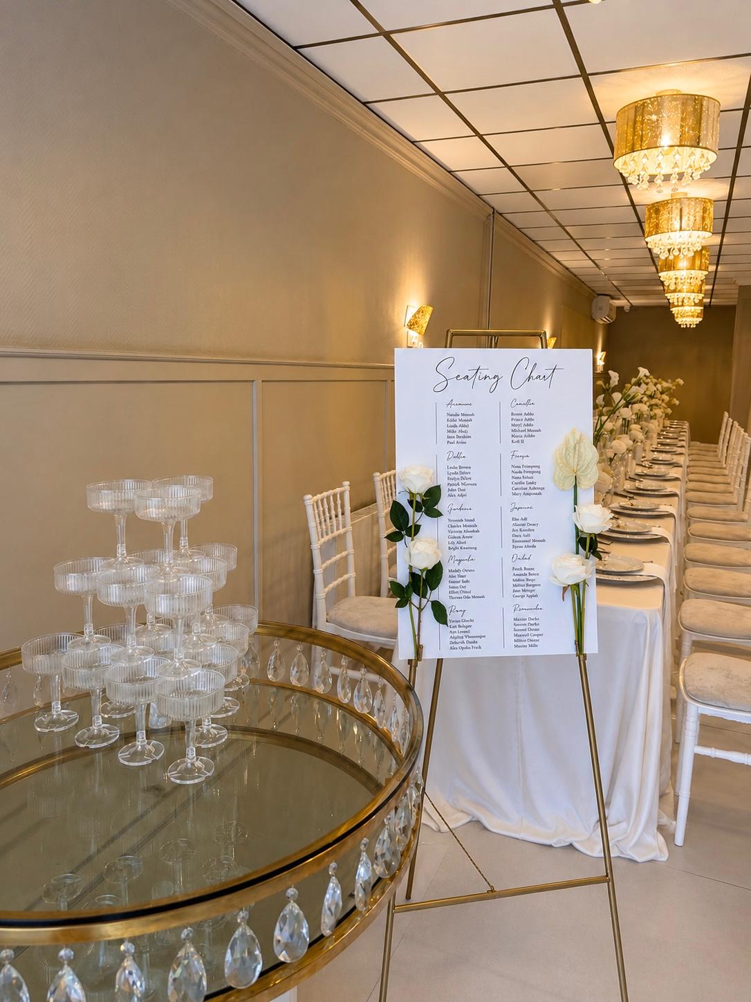 Seating chart op gouden ezel naast een champagnetoren en lange gedekte tafel