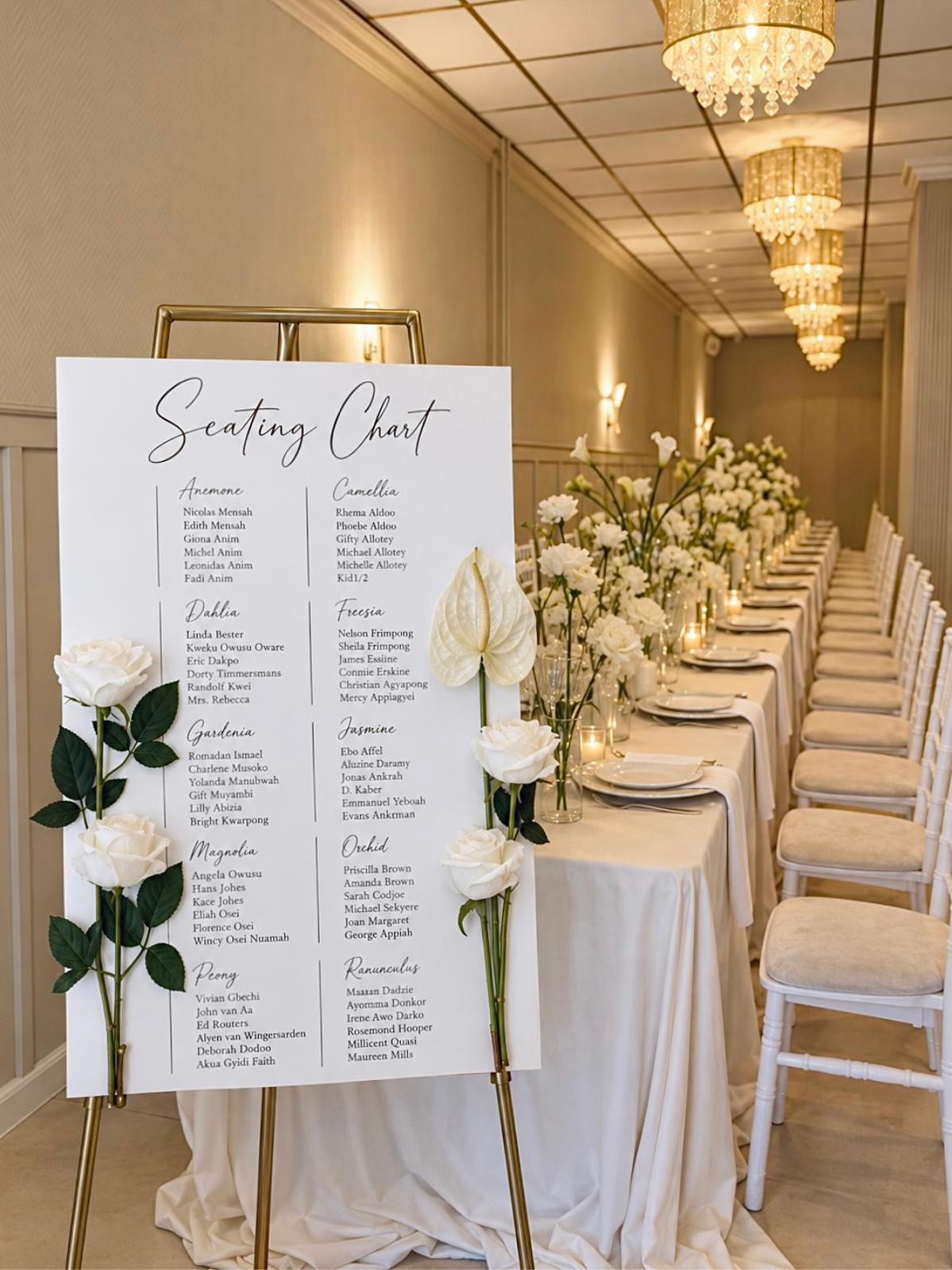 Seating chart op gouden ezel met witte rozen naast een lange gedekte tafel