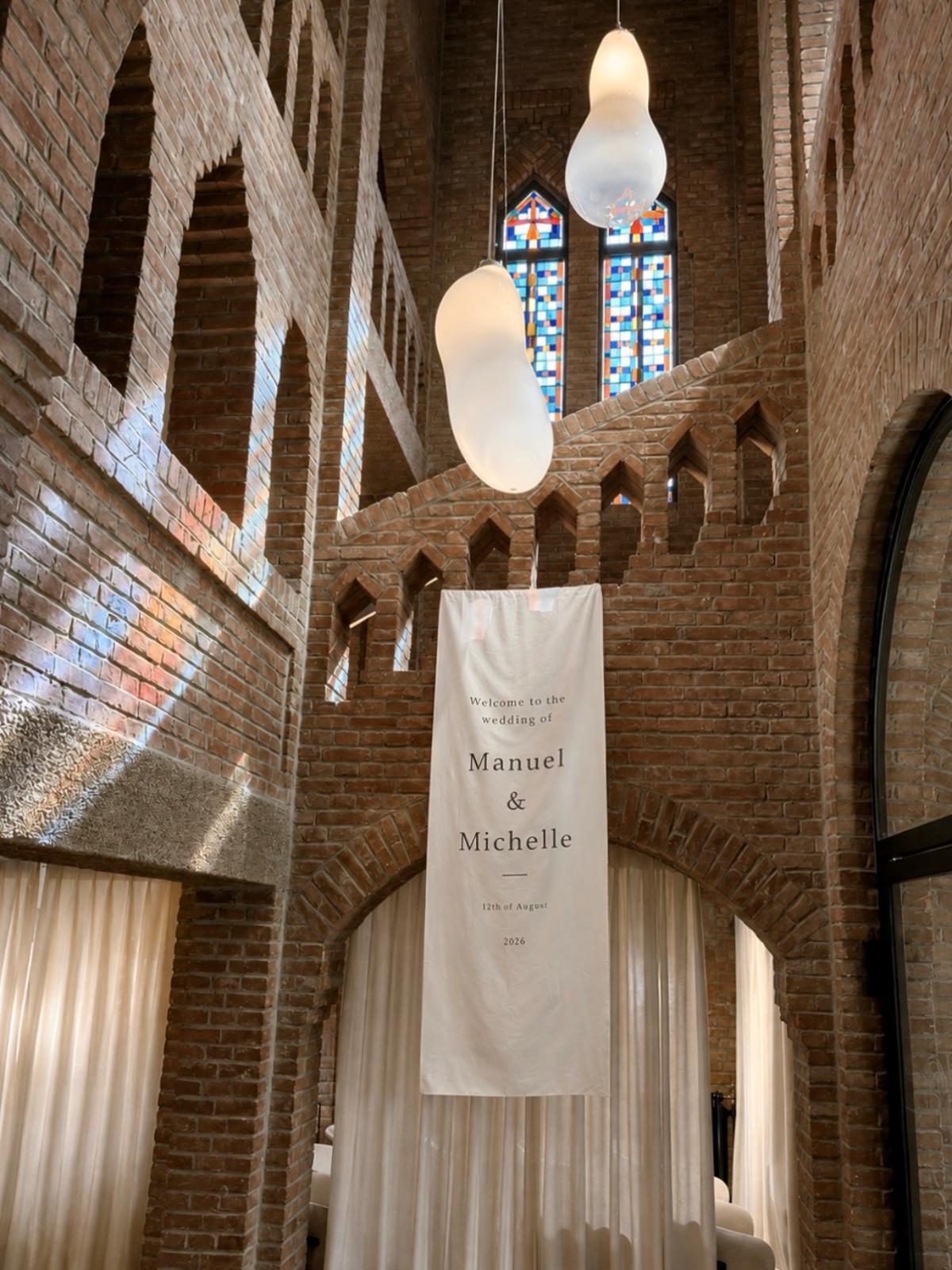 Hangende welkomstbanner voor een bruiloft in een bakstenen zaal